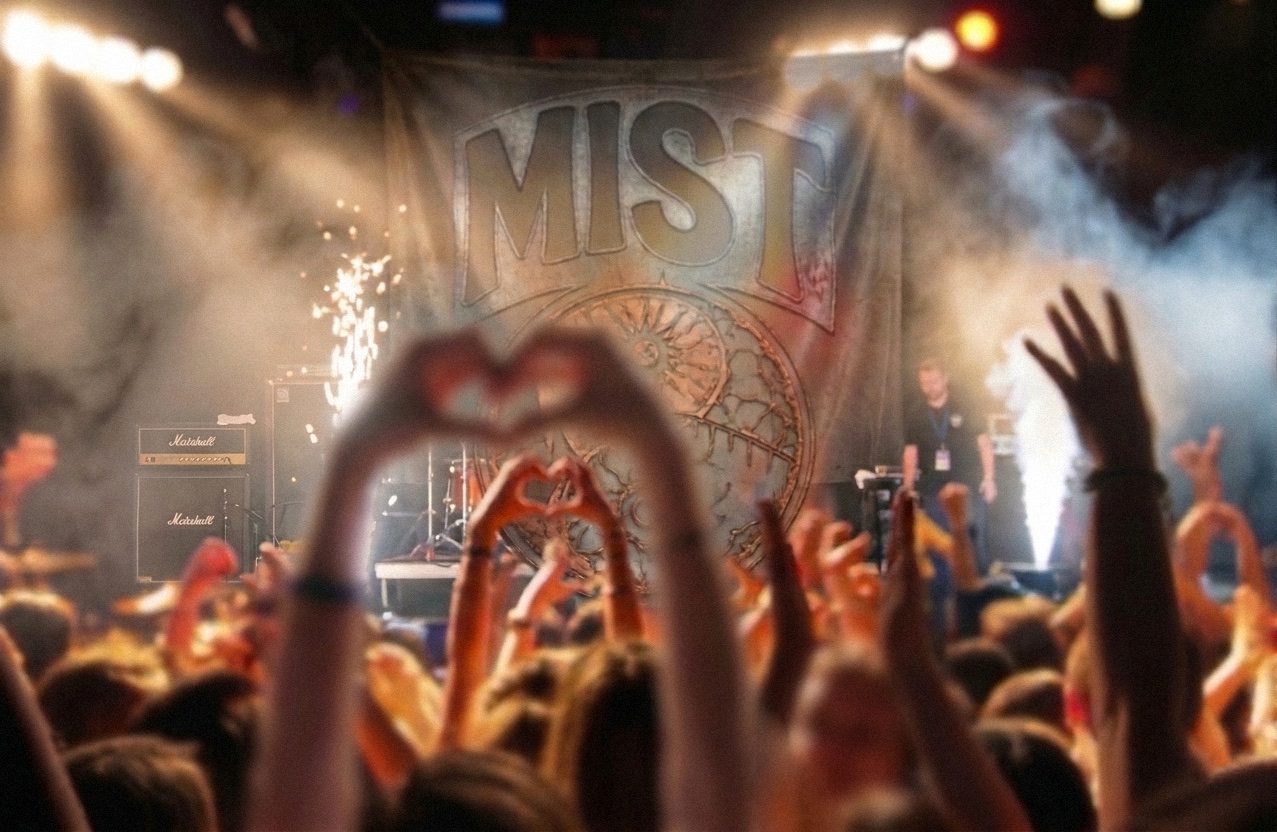 Crowd at MIST Festival in front of the MIST stage banner, hands raised in heart shapes